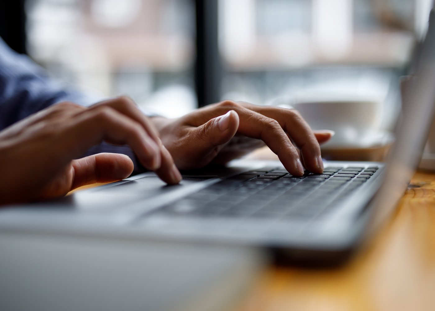 Close-up of hands typing on a laptop keyboard