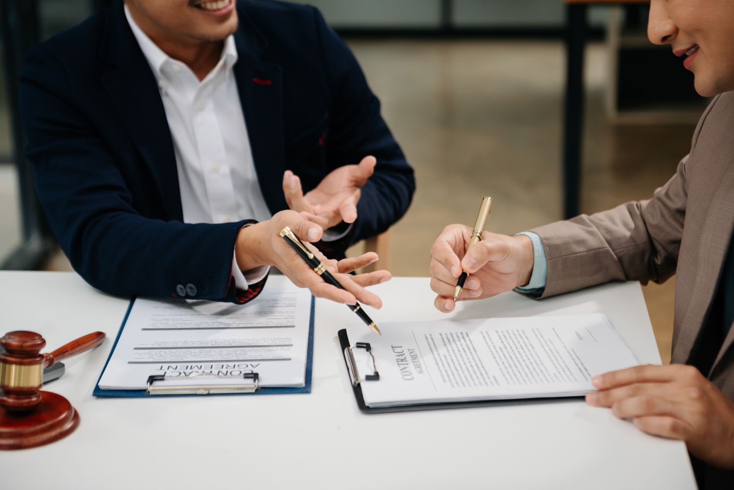 Attorney and client reviewing a contract across a desk before signing