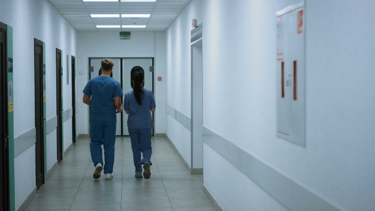 Two care staff walking down a long-term care facility corridor