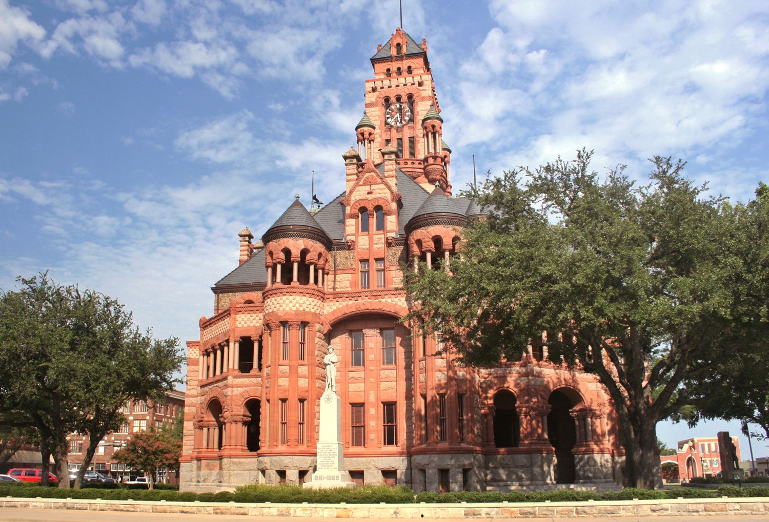 Historic county courthouse building surrounded by trees