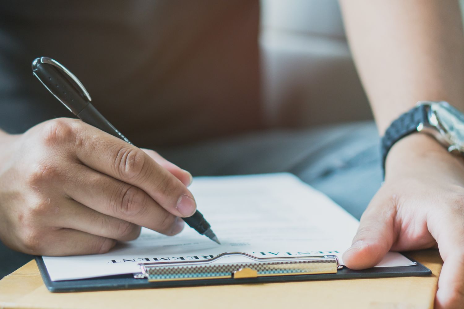 Close-up of a hand writing notes with a pen