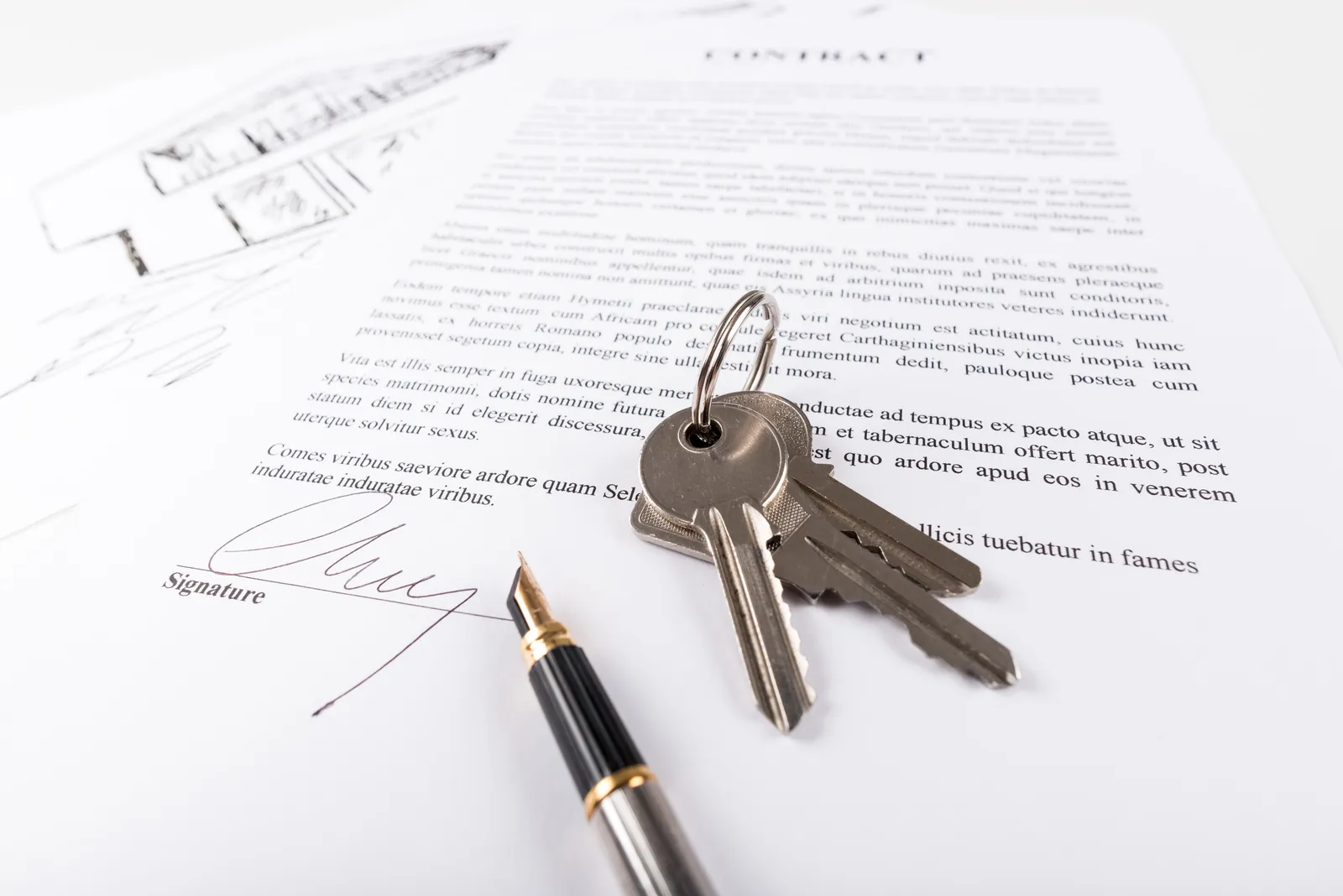 A signed property contract with a fountain pen and a set of house keys resting on it